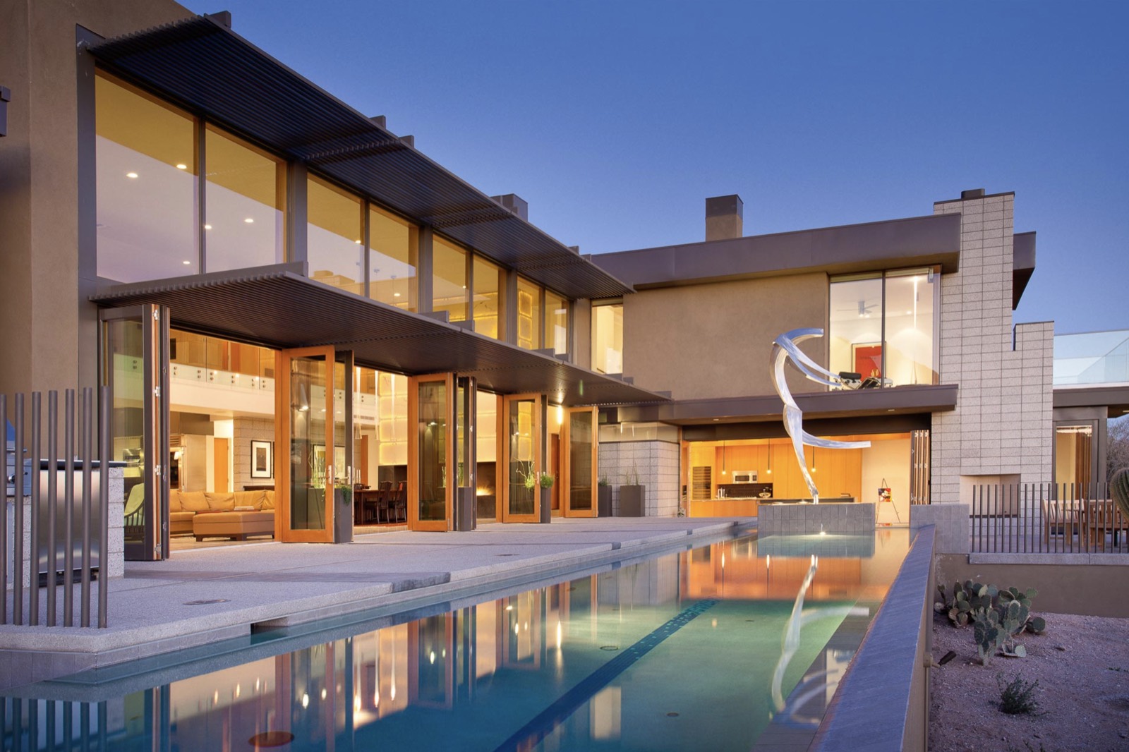 Outswing multi‑panel bi‑fold doors, desert evening, pool open